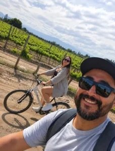Pareja junto a bicicletas frente a los viñedos de Bodega MEVI
