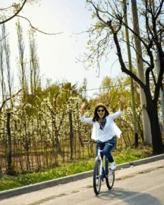 Ciclista recorriendo un camino entre árboles y viñedos