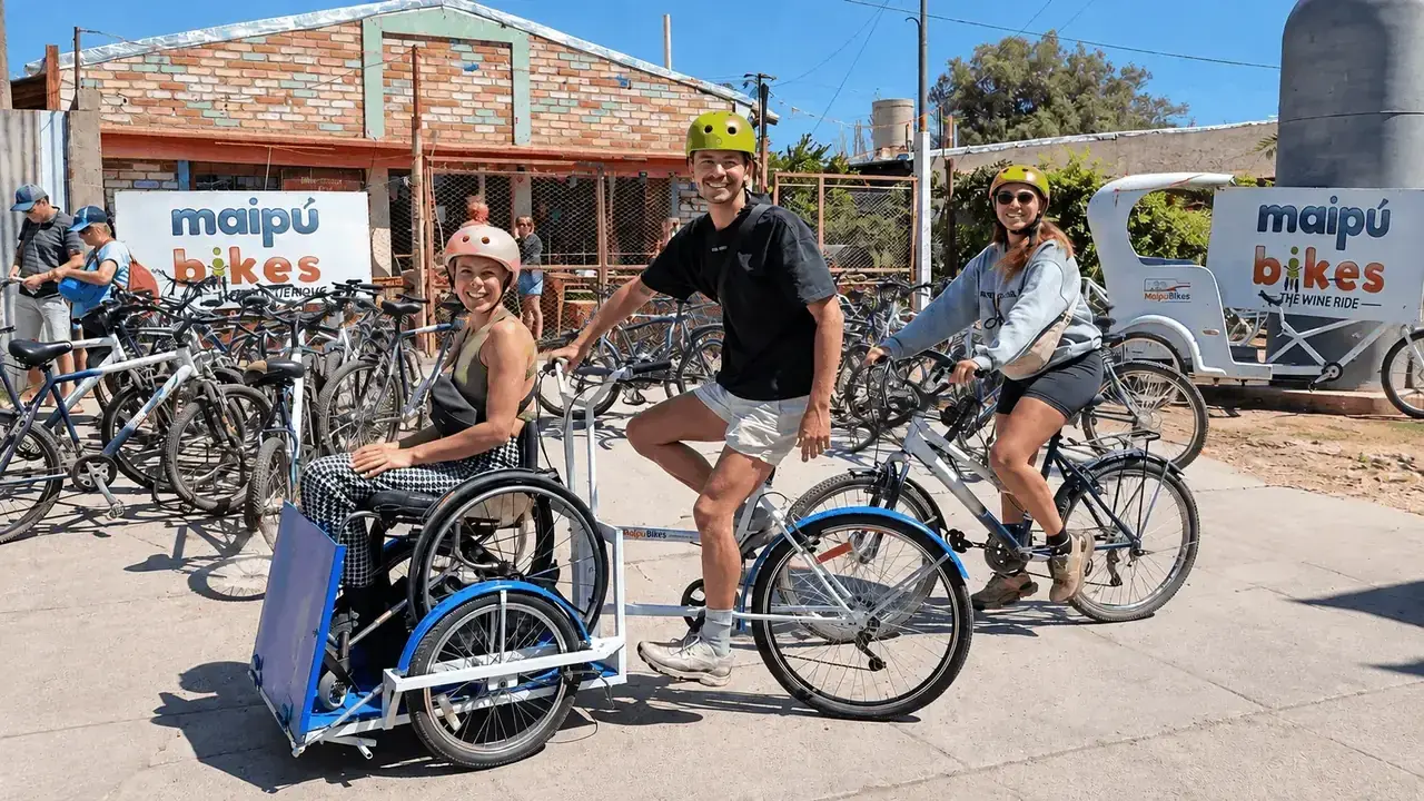 Casal da Inglaterra se preparando para conhecer a Rota do Vinho de Maipú em uma bicicleta adaptada junto a outros turistas na Maipu Bikes