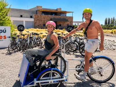 Pareja recorriendo la Ruta del Vino de Maipú en bicicleta adaptada frente a Bodega Tempus Alba
